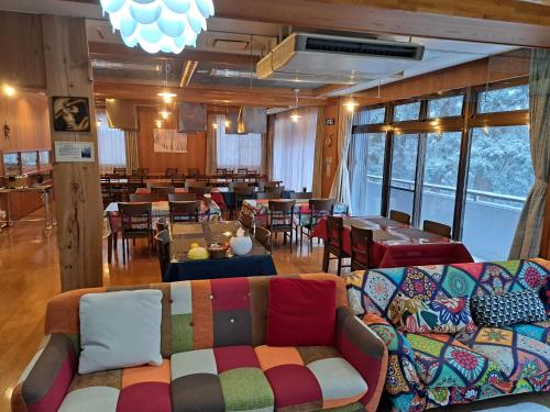 restauracja z kanapami i stołami oraz jadalnią w obiekcie 大山ベースキャンプ（Daisen Basecamp） w mieście Daisen