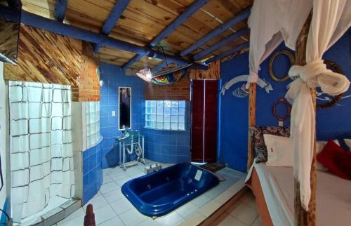 ein Bad mit einer blauen Badewanne in einem Zimmer in der Unterkunft Cabañas Tres Joyas in San Miguel Regla