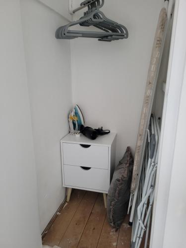 a room with a bed and a dresser next to a ladder at Little Oaks House - Historic Charm & Modern Comfort in Colchester by Catchpole Stays in Colchester