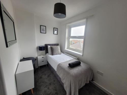 a small bedroom with a bed and a window at Little Oaks House - Historic Charm & Modern Comfort in Colchester by Catchpole Stays in Colchester
