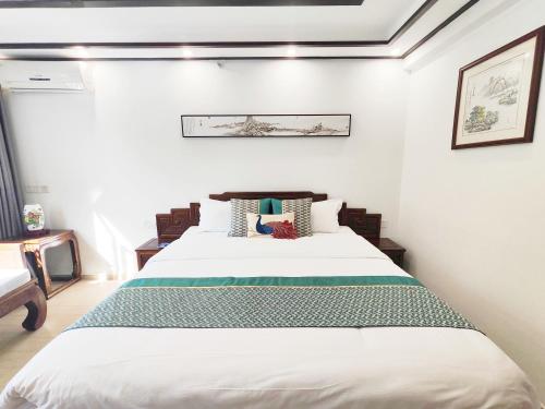 a bedroom with a large bed in a room at Tongli Lanshe Garden B&B in Suzhou