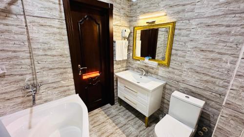 a bathroom with a sink and a toilet and a mirror at Garden Plaza Bukhara in Bukhara