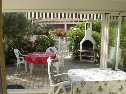 un patio avec une table, des chaises et un barbecue dans l'établissement beautiful holiday home 2 near the beach, à Portiragnes