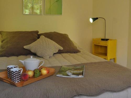 a tray with a tea pot and fruit on a bed at Majestic apartment in La Vancelle in La Vancelle