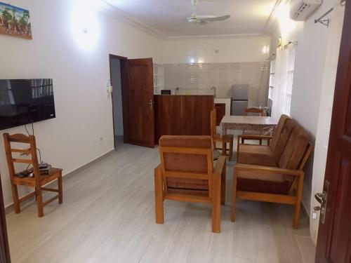 a living room with a dining room table and chairs at Appartement à Fidjrossè in Cotonou