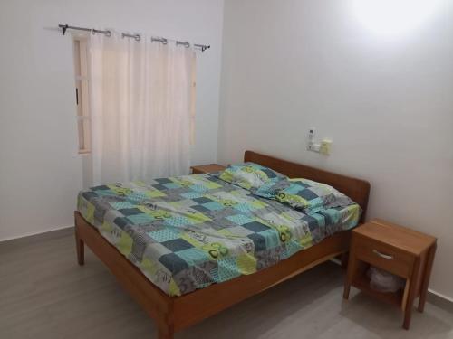 a bedroom with a bed with a quilt on it at Appartement à Fidjrossè in Cotonou