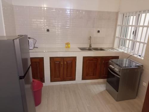 a kitchen with a sink and a stove at Appartement à Fidjrossè in Cotonou