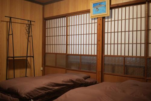 1 dormitorio con 1 cama, ventana y 1 cama en omusubi guest house (JAPANESE　STYLE）, en Mamihara
