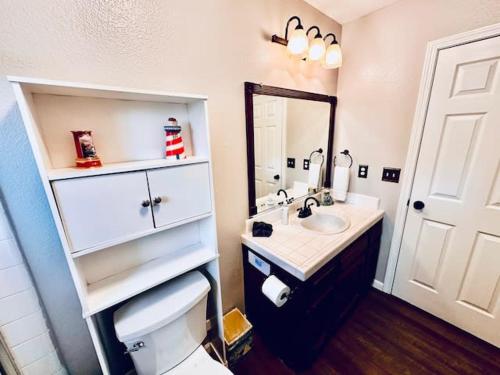een badkamer met een wastafel, een toilet en een spiegel bij Lighthouse Suite Pet Friendly Hot Tub Sleeps 4 in Coarsegold