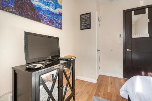 a living room with a flat screen tv on a table at Sunny room on Manhattan’s Upper west side in New York