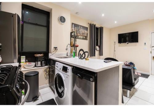 a kitchen with a washing machine and a sink at Sunny room on Manhattan’s Upper west side in New York