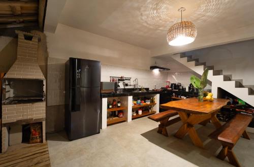 een keuken met een houten tafel en een koelkast bij Casa Vivá in Arraial d'Ajuda
