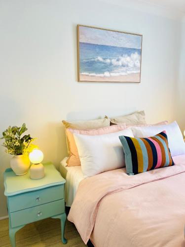 a bedroom with two beds and a table with a plant at Sunshine Retreat Modern 3BR Haven in St Marys