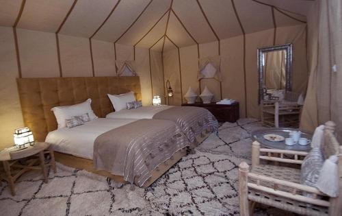 Merzouga Luxury Traditional Camp في مرزوقة: غرفة نوم بسرير كبير في خيمة