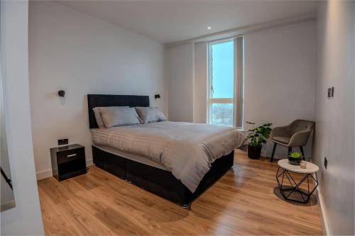 um quarto com uma cama grande e uma cadeira em 2 Bedroom Flat near Stanmore Station em Stanmore