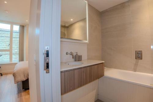 a bathroom with a sink and a bath tub at 2 Bedroom Flat near Stanmore Station in Stanmore