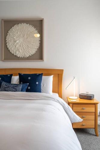 a bedroom with a bed and a table with a lamp at Sailors' Retreat 3BR Pool Beach Study in Largs