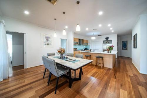 a kitchen and dining room with a table and chairs at Sailors' Retreat 3BR Pool Beach Study in Largs