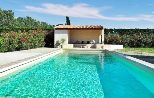a swimming pool in front of a house with flowers at Le Loft De L Ecurie in Maillane