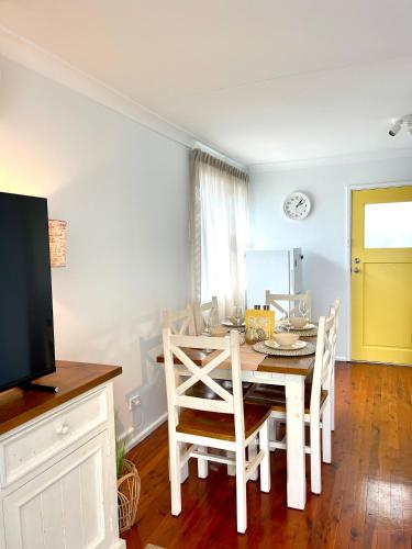 a dining room with a table and chairs and a television at Sunshine Retreat Modern 3BR Haven in St Marys