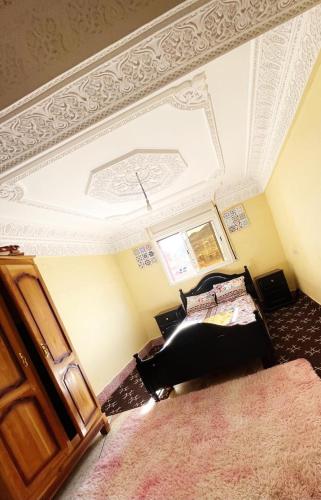 a bedroom with a bed and a white ceiling at Meuble BenTaleb Younes in Khenifra