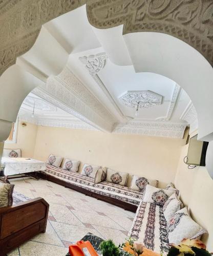 een woonkamer met een bank en een plafond bij Meuble BenTaleb Younes in Khenifra