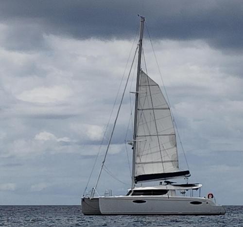a sailboat in the ocean on a cloudy day at catamaran in Les Trois-Îlets