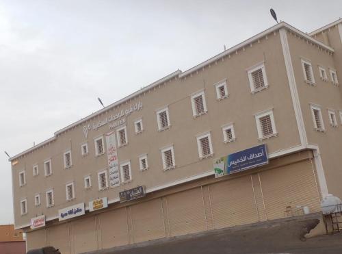 a large tan building with signs on the side of it at بارك فيو للوحدات السكنية in Birzayn