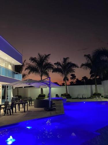 a swimming pool at night with blue lights at Chalét de Lujo en Rozo! in Rozo