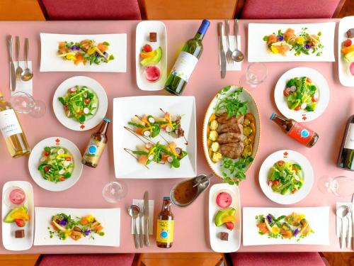 a pink table with plates of food on it at Hotel Ichinose in Yamanouchi