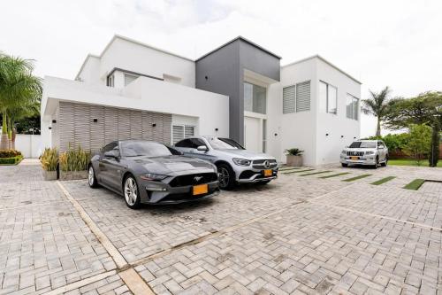two cars parked in front of a house at Chalét de Lujo en Rozo! in Rozo