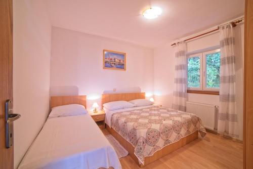 1 Schlafzimmer mit 2 Betten und einem Fenster in der Unterkunft Apartments with a parking space Supetarska Draga - Gonar, Rab - 22586 in Rab