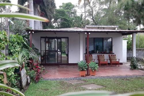 Casa blanca pequeña con patio con sillas en Jardín Paraíso, en Amatitlán