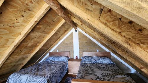 two beds in a attic with wooden ceilings at Cabañas El Marqués Zacatlán con Starlink in Zacatlán