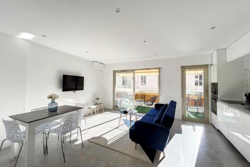 un salon avec une table et un canapé bleu dans l'établissement LE VERDI - Fully renovated 2P apartment - PERFECT CONGRESS, à Cannes