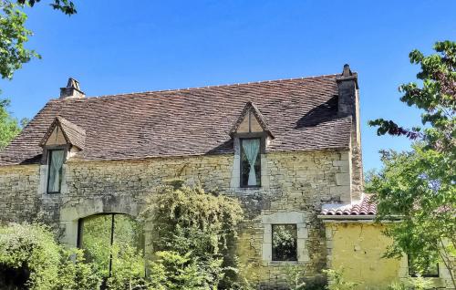 Cette ancienne maison en pierre possède des fenêtres et un toit. dans l'établissement Le Causse, à Florimont-Gaumiers