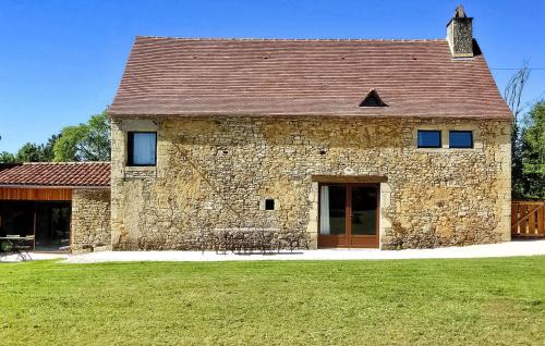 - un grand bâtiment en pierre avec une grande pelouse dans l'établissement Le Causse, à Florimont-Gaumiers