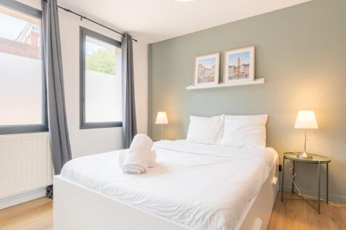 un grand lit blanc dans une chambre avec une fenêtre dans l'établissement Vieux Lille : Equipped studio, à Lille