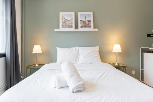 - une chambre avec un lit blanc et 2 lampes dans l'établissement Vieux Lille : Equipped studio, à Lille
