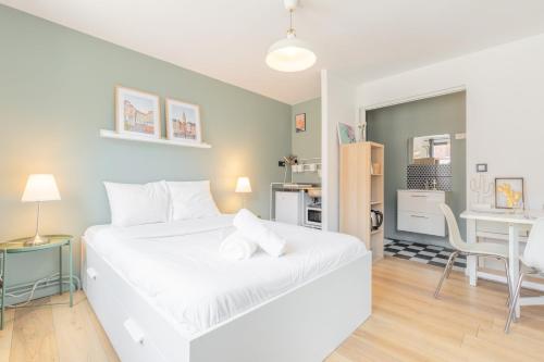 une chambre avec un lit blanc et un bureau dans l'établissement Vieux Lille : Equipped studio, à Lille