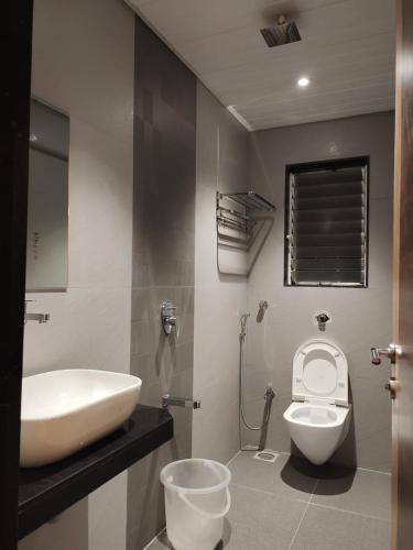 a bathroom with a sink and a toilet at Hotel Shelter Palace in Navi Mumbai