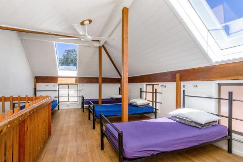 a room with three beds and a ceiling at Aquarius Backpackers Resort in Byron Bay