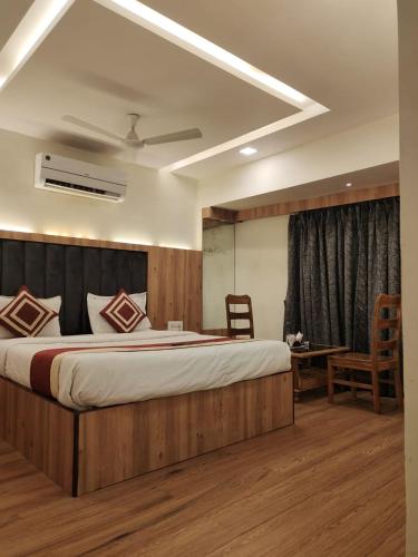 a bedroom with a large bed and a table at Hotel Shelter Palace in Navi Mumbai