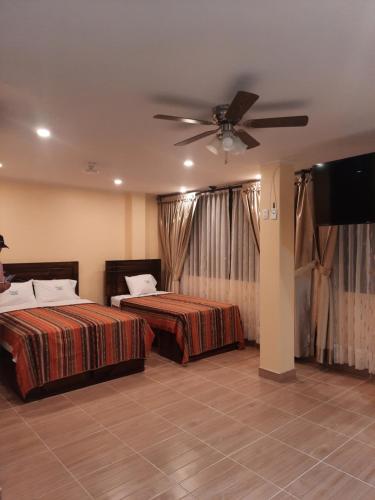 1 dormitorio con 2 camas y TV de pantalla plana en BRISAS DE LA BAHIA HOTEL, en Paracas
