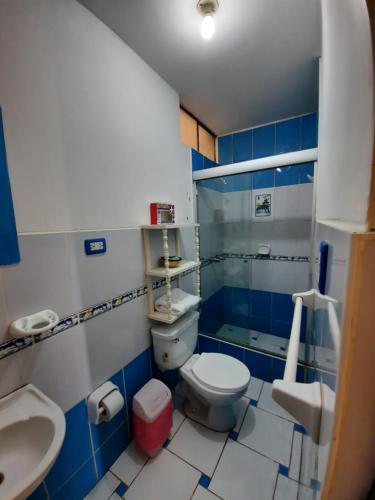 baño azul y blanco con aseo y lavamanos en BRISAS DE LA BAHIA HOTEL, en Paracas