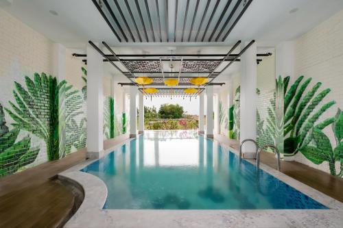 a swimming pool in the middle of a building with plants at Thien Thanh Central Boutique Hotel by Minova in Hoi An