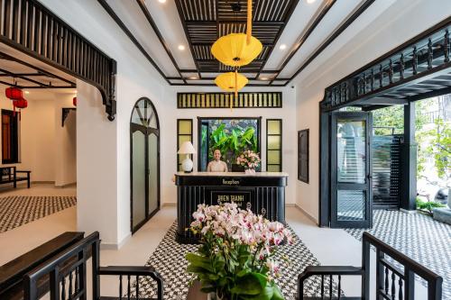 a living room with a fireplace and flowers at Thien Thanh Central Boutique Hotel in Hoi An