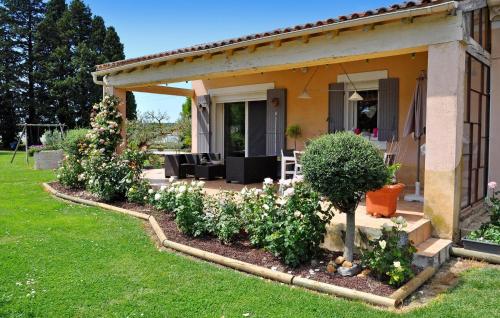 une maison avec une terrasse fleurie dans la cour dans l'établissement Palunettes, à Graveson