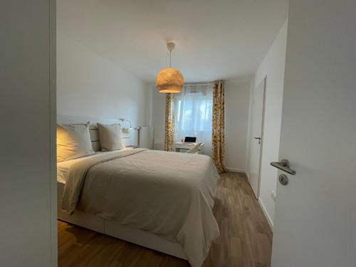 a white bedroom with a bed and a window at Apartment near to Paris CDG in Aulnay-sous-Bois