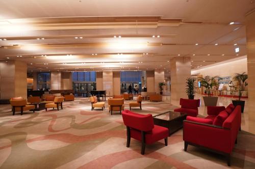un vestíbulo de un hotel con sillas y mesas rojas en ANA Crowne Plaza Kobe, an IHG Hotel, en Kobe